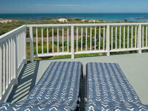 a balcony with a bench and the beach at Pearly Beach House in Pearly Beach