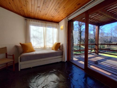 ein Schlafzimmer mit einem Bett und einem großen Fenster in der Unterkunft Paihuen - Resort De Montaña in San Martín de los Andes