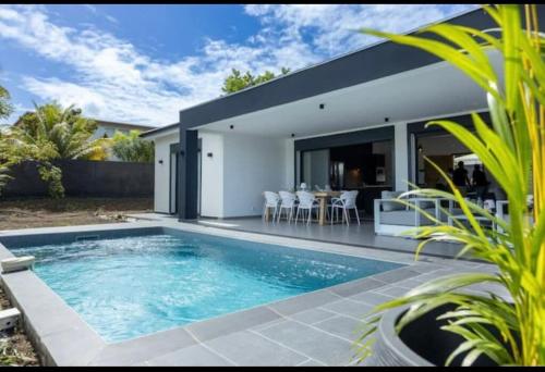 a swimming pool in the backyard of a house at Villa CANELLE FWI 4 Étoiles piscine jacuzzi beach surf in Le Moule