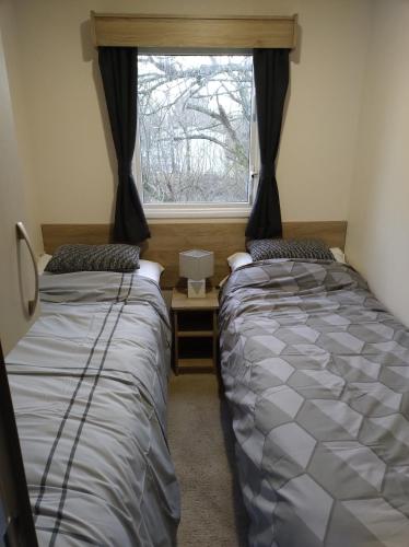 two beds in a room with a window at Swanns retreat in Tattershall