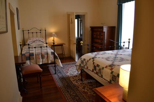 a bedroom with a bed and a table and a window at Robe House Heritage Accommodation in Robe