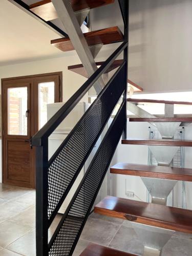 a spiral staircase in a house with a wooden door at Solar de Roca in Embalse