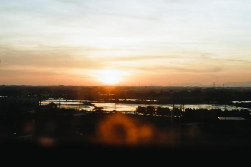 a sunset with the sun setting over a river at Modern Oasis*Heart of City*Fast Wi-Fi/Netflix WFH in Iloilo City