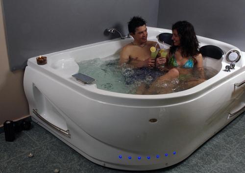 a man and woman sitting in a bathtub at Хотел Дикас in Smolyan