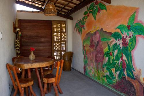 a dining room with a table and a painting on the wall at Milagres de Minas in São Miguel dos Milagres