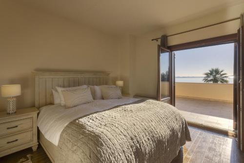 a bedroom with a bed with a view of the ocean at Porto Heli - Heaven on Earth Villa in Ermioni