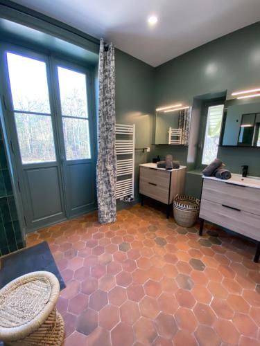 une chambre avec une salle de bain avec un lavabo et un miroir dans l'établissement le Pavillon d'Hermières, proche Disneyland Paris, à Favières