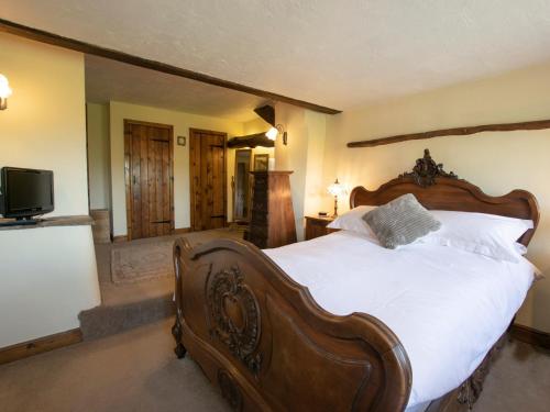 um quarto com uma grande cama de madeira e uma televisão em 2 Bed in New Mills 75029 em Mellor