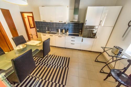 a kitchen with white cabinets and a table and chairs at OH Apartments & Rooms in Ljubljana