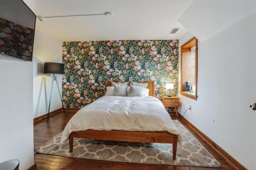 ein Schlafzimmer mit einem großen Bett mit Blumentapete in der Unterkunft Overlook Brandywine Valley 