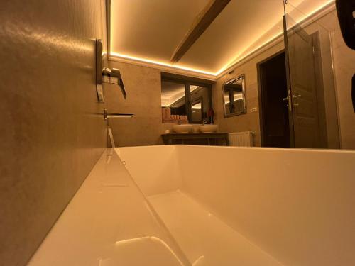 a large white bath tub in a bathroom with a mirror at Lake House by NIVO in Pavlovci