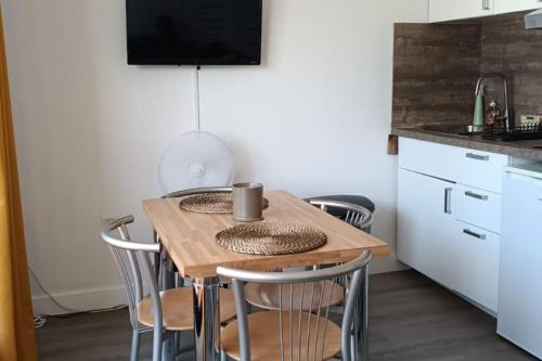 a small kitchen with a wooden table and chairs at Appartement avec vue sur le lac in Lognes