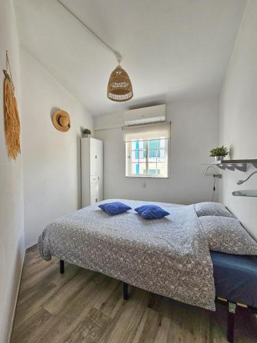 a bedroom with a bed with blue pillows on it at Casa Albufeira in Albufeira