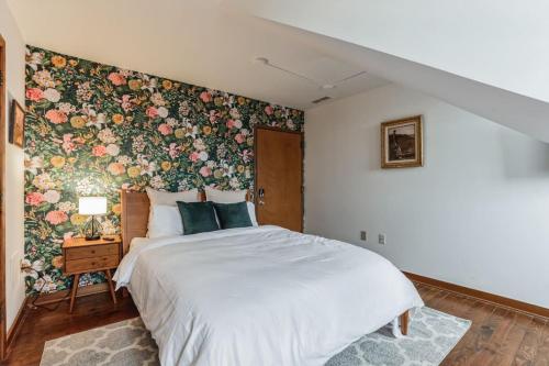 1 dormitorio con 1 cama grande y papel pintado con motivos florales en Charming Studio in Thornton PA, 