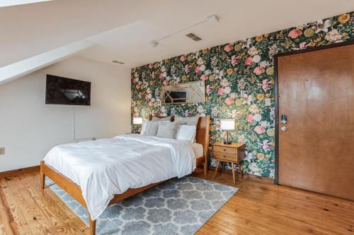 1 dormitorio con 1 cama grande y papel pintado con motivos florales en Historic Thornton Studio Retreat, 