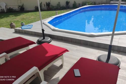 維勒班特的住宿－Villa d'exception avec Piscine，游泳池旁的红色长凳