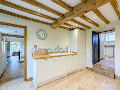 a kitchen with a sink and a clock on the wall at 3 Bed in Gwynfryn 83938 in Coedpoeth