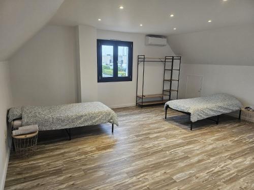 deux lits dans une chambre avec parquet dans l'établissement MAISON ACTI SUD Tout confort - Zone commerciale CHENOVE, à Chenôve