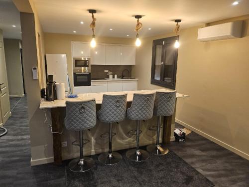 une cuisine avec comptoir et tabourets de bar dans l'établissement MAISON ACTI SUD Tout confort - Zone commerciale CHENOVE, à Chenôve
