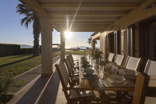 a long wooden table and chairs on a patio at Porto Heli - Heaven on Earth Villa in Ermioni