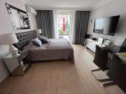 - une chambre avec un lit et une télévision dans l'établissement New - cosy & nice Apartment in Palais Miramar, à Cannes
