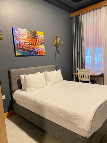 een slaapkamer met een bed met een schilderij aan de muur bij Unique Suite - On the Kadıköy seaside in Istanbul