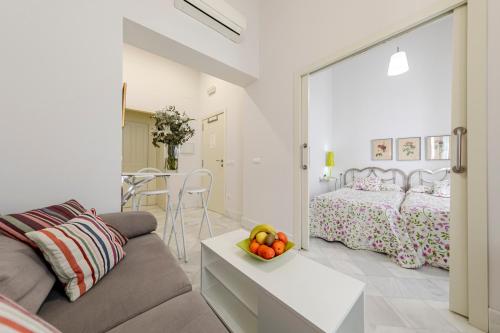 uma sala de estar com um sofá e um quarto em Sevilla Home Center em Sevilha