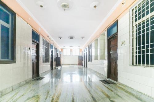 pusty korytarz budynku z białymi ścianami i drewnianymi podłogami w obiekcie SPOT ON Hotel Anand Bhawan w mieście Aligarh