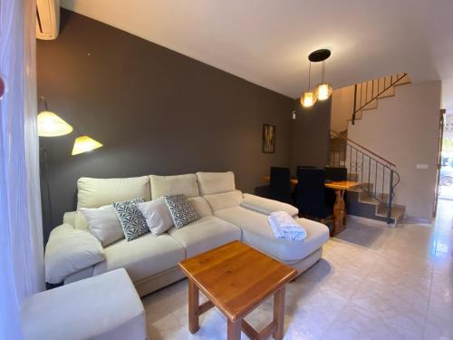 uma sala de estar com um sofá branco e uma mesa em Casa Sobrestany L’Estartit em L'Estartit