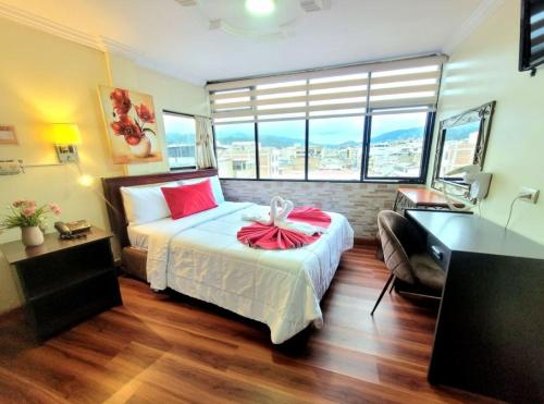 ロハにあるHotel Virgen del Cisneのベッドと机と窓のある寝室