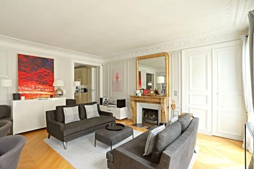 ein Wohnzimmer mit einem Sofa und einem Kamin in der Unterkunft Luxurious Flat Place Vendome in Paris