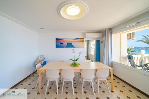een eetkamer met een tafel en stoelen bij Apartment front line Jakarta 1 Sea View in El Campello