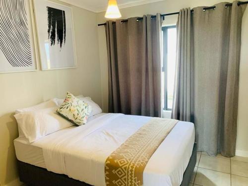 a bedroom with a large bed with a window at Stylish space Green Creek Estate next to The Blyde in Pretoria