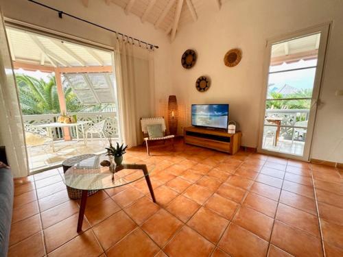 a living room with a table and a television at Passiflora in Orient Bay
