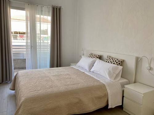 Un dormitorio blanco con una cama grande y una ventana en Casa Antonio - apartamento Orion en Playa de San Juan