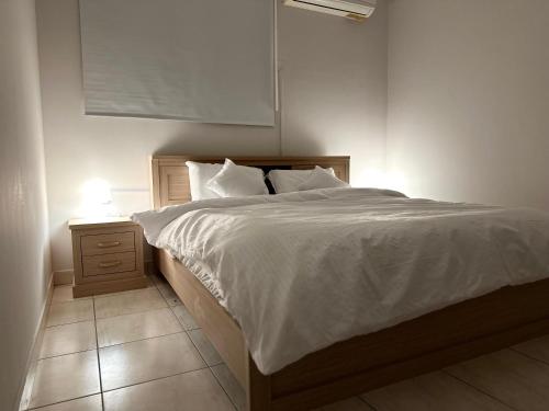 een slaapkamer met een wit bed met een nachtkastje en een bed sidx sidx sidx bij شقة فاخرة بدخول ذاتي/غرفة و صالة و مطبخ و حمام in Riyad