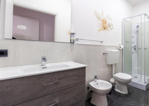 La salle de bains est pourvue d'un lavabo, de toilettes et d'un miroir. dans l'établissement europa bed, à Parme