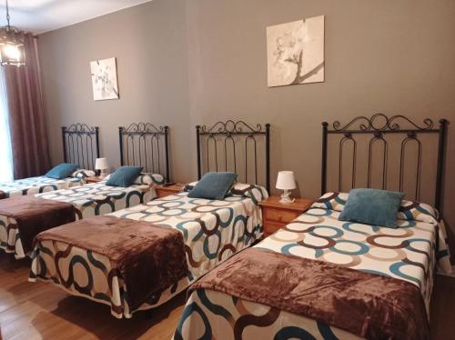 a group of four beds in a room at Hospedaje Don Pelayo in Gijón