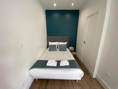 a bedroom with a bed with a blue wall at studio BORDEAUX CHARTRONS 2 in Bordeaux