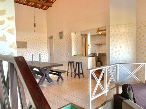 a living room with a table and a kitchen at Casa Tío Luiz in Aquiraz