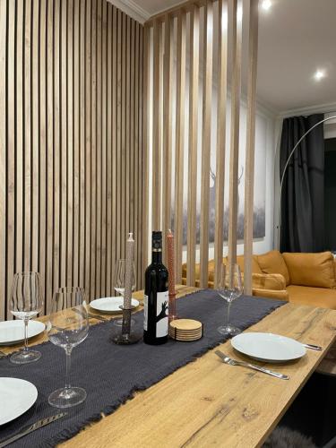 a dining table with a bottle of wine and glasses at Blick Glockenturm in Sankt Andreasberg