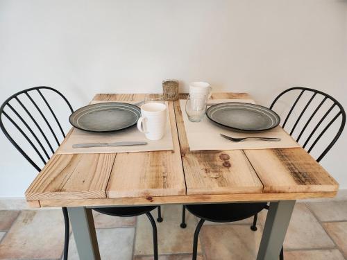 a wooden table with two empty plates on it at Domaine Les Gendalis in Saint-Saturnin-les-Avignon