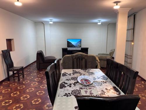 a dining room with a table and a television at Departamento como en casa in La Paz