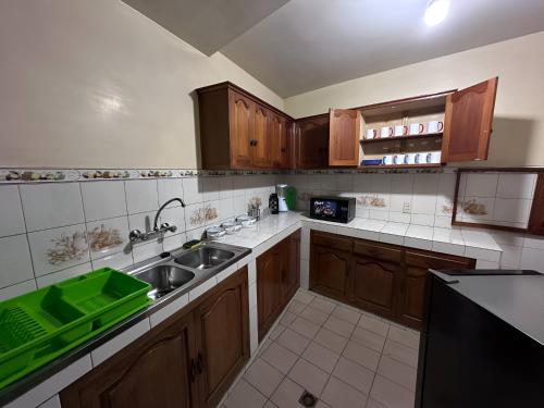 cocina con armarios de madera y fregadero verde en Departamento como en casa en La Paz