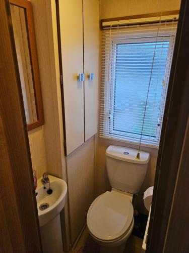 a small bathroom with a toilet and a sink at 10 min walk to South Devon beach in Paignton