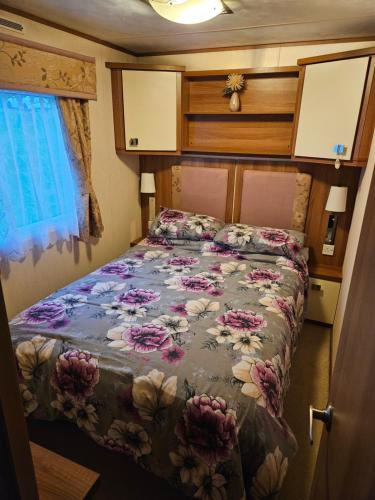 a bedroom with a bed with a floral comforter at 10 min walk to South Devon beach in Paignton