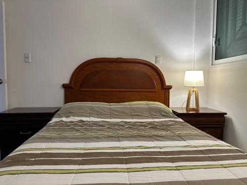 a bed with a striped comforter in a bedroom at Apto comodo, muy cerca de playa 101 in Mazatlán