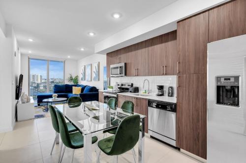 a kitchen with a glass table and green chairs at Charming 3-Bed Mins from Brickell With Free Parking in Miami