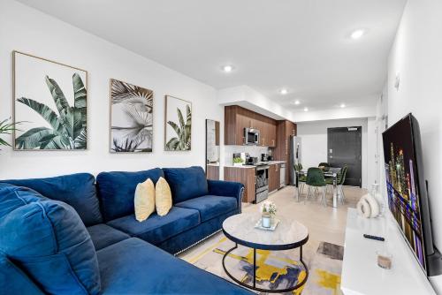 a living room with a blue couch and a table at Charming 3-Bed Mins from Brickell With Free Parking in Miami