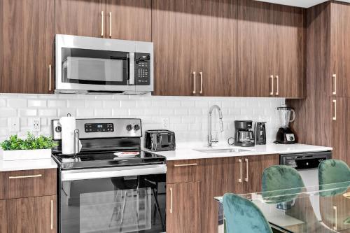 a kitchen with stainless steel appliances and wooden cabinets at Charming 3-Bed Mins from Brickell With Free Parking in Miami